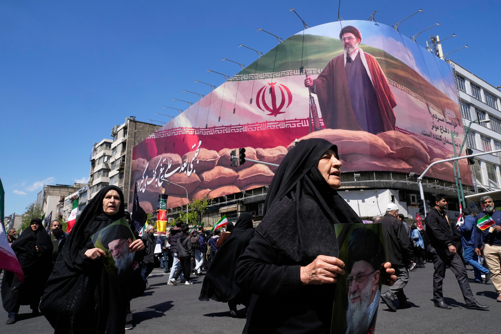 Women walk past a billboard depicting Iran's Supreme Leader Mojtaba Khamenei as government supporters gather to mark the 40th day since the killing of his father, slain Supreme Leader Ayatollah Ali Khamenei, in Tehran, Iran on April 9, 2026. (Photo by Vahid Salemi / AP Photo)